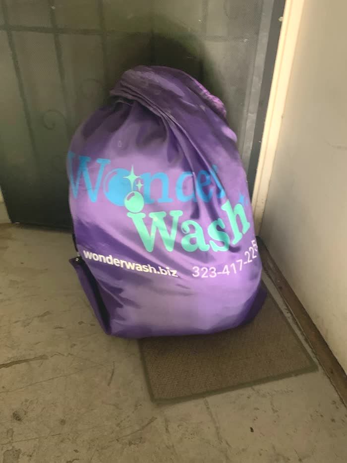 A WonderWash bag by an apartment door, ready for pickup